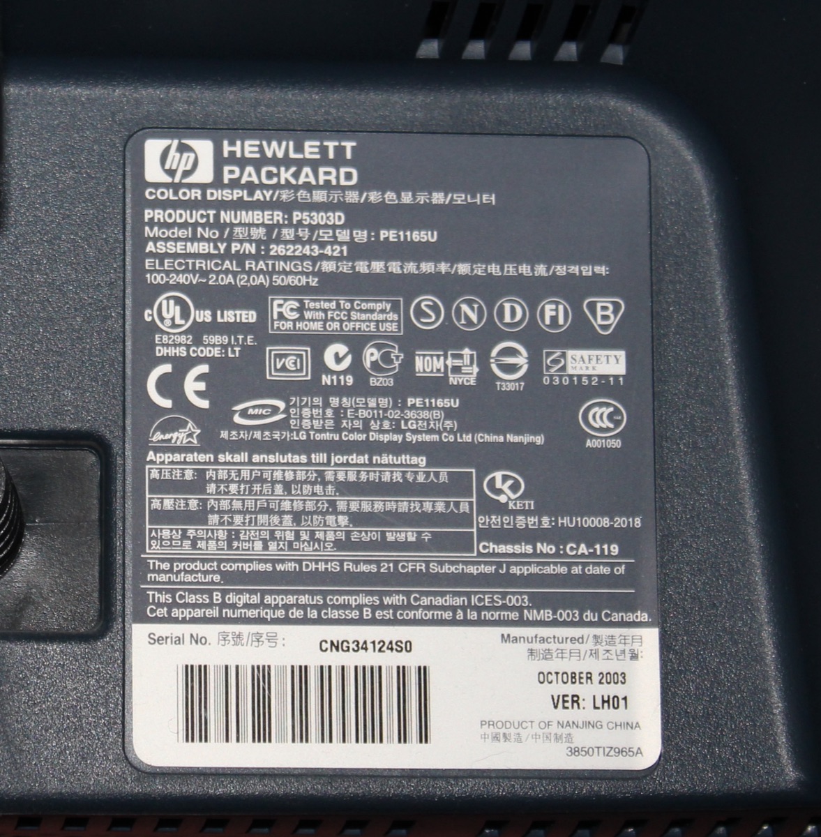 The rating plate on the back of an HP monitor, with its product number, model number and serial number among certification marks and text in several languages